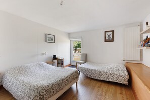 A room with two beds, a desk, a chair, and a radiator. - Bed and Breakfast 'Chambre Laurier' with Shared Pool, Shared Garden and Wi-Fi (Le Controis-en-Sologne)