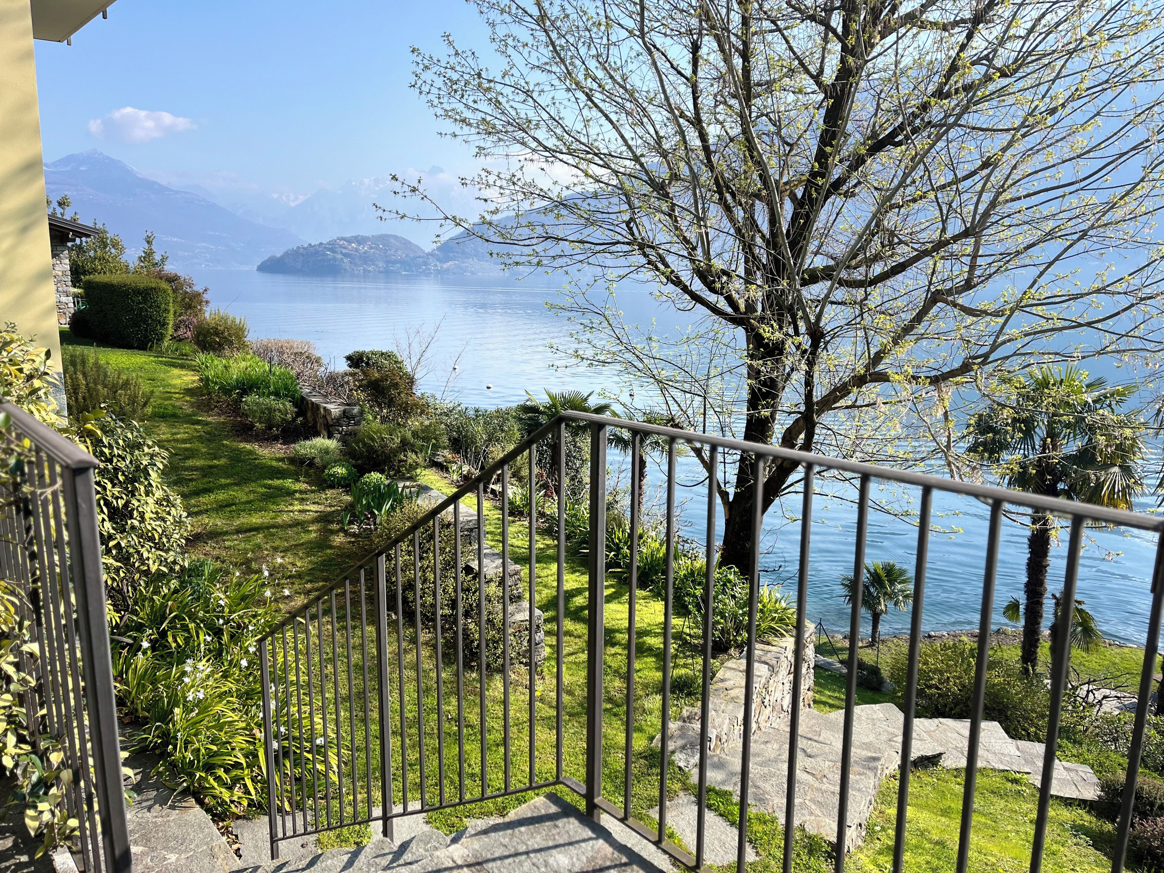 A staircase leading to a balcony overlooking a lake with a mountain in the background.
