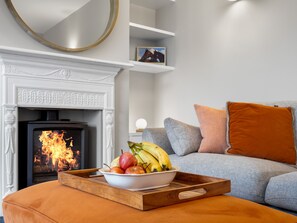 Ein Wohnzimmer mit Kamin, einer Couch und einer Fruchtschale.
