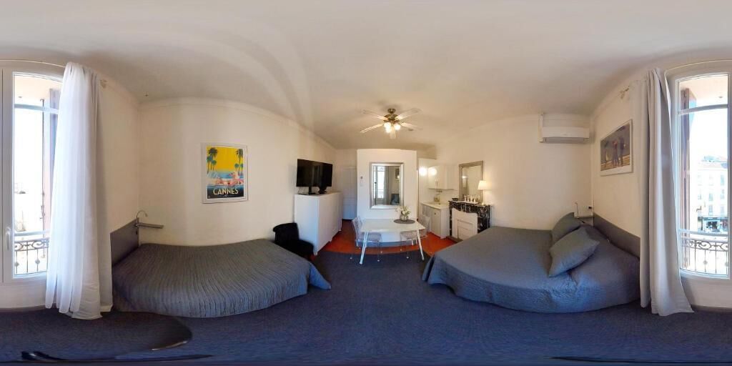 Ein Zimmer mit zwei Einzelbetten, einem kleinen Tisch, einem Fernseher und einem Spiegel.