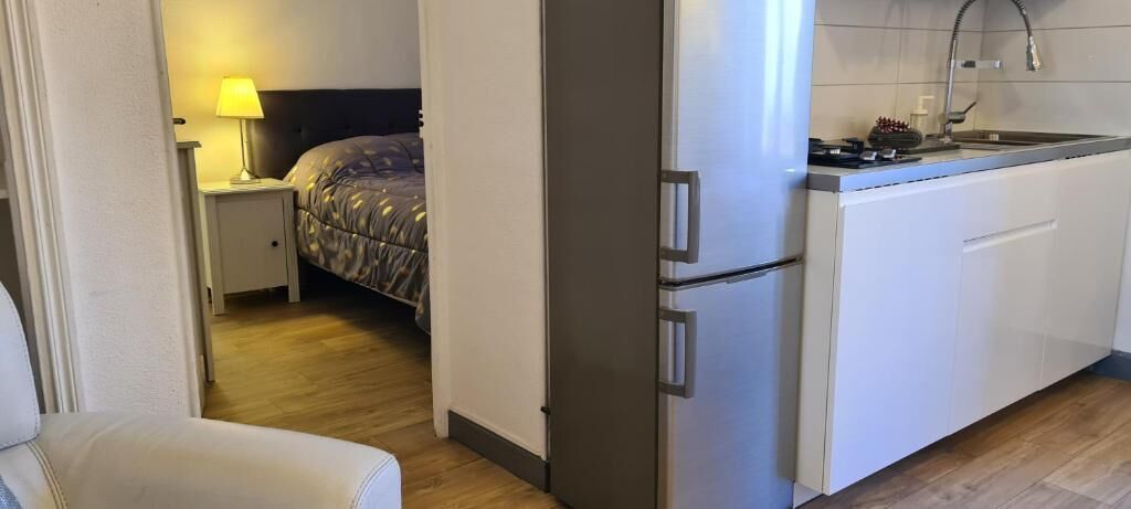 A compact kitchenette with a refrigerator, a stove, and a sink.