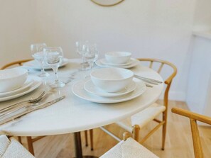A round dining table set with white plates, bowls, and cutlery. - Cozy 3/2 Rose Bowl, Pasadena with AC and Parking (Altadena)