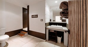 Ein Badezimmer mit Toilette, Waschbecken und Duschbereich.