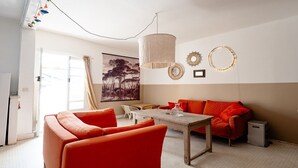 Une pièce comprenant un canapé, une table, une chaise, une lampe et un tableau accroché au mur.