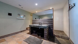 Une salle de bain avec un meuble-lavabo en bois, un évier en granit et un grand miroir.