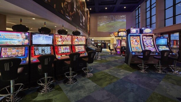 A casino with multiple slot machines and bar stools. - Grand Hôtel du Casino de Dieppe (Dieppe)