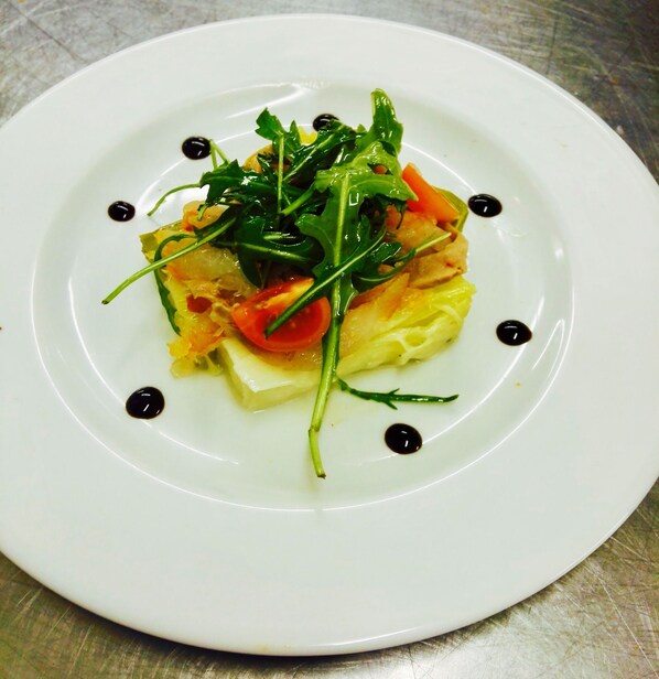 A white plate with a dish of omelette, greens, and tomatoes, garnished with black dots. - Grand Hôtel du Casino de Dieppe (Dieppe)