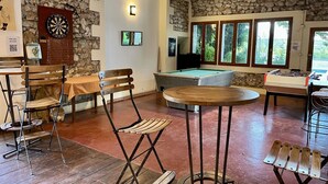 A room with a pool table, dartboard, and a stone wall. - ZEcamping 3* piscine pet friendly locatif 90m2 6 pers (Quinson)