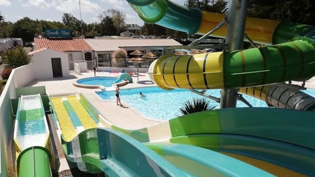 Ein Wasserpark mit mehreren Rutschen und einem Schwimmbecken.