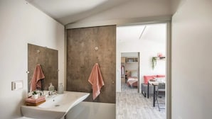 Ein modernes Badezimmer mit einem großen Waschbecken, zwei Handtüchern und einem Spiegel.