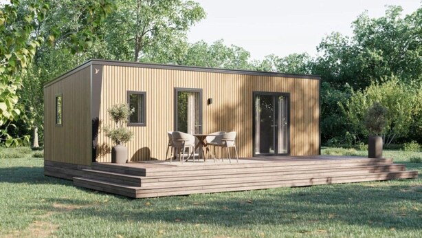 Een moderne, gelijkvloerse houten blokhut met een terras, twee ramen en een deur.