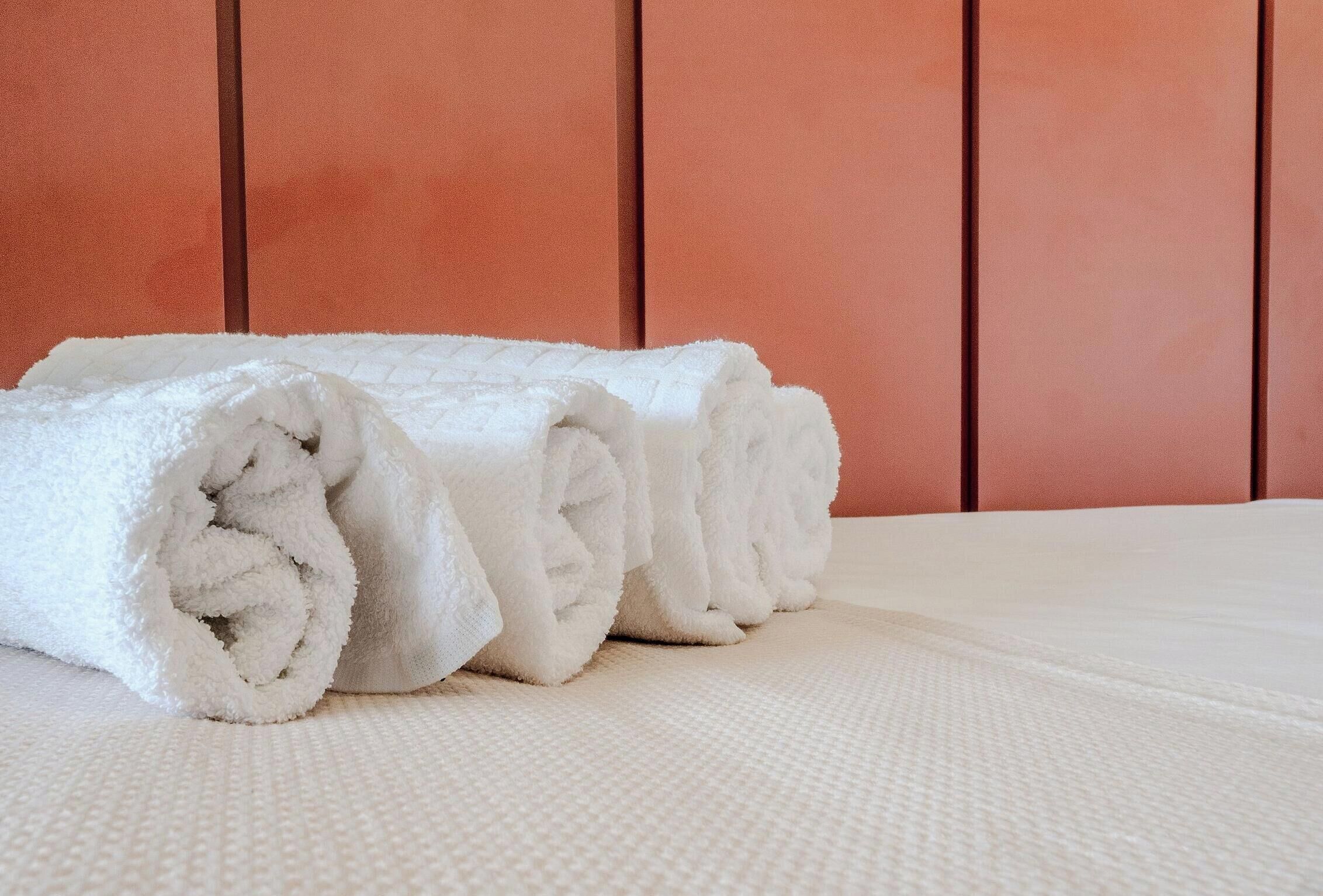 Un lit bien fait, avec du linge de lit blanc et une couvre-lit blanche à motifs.