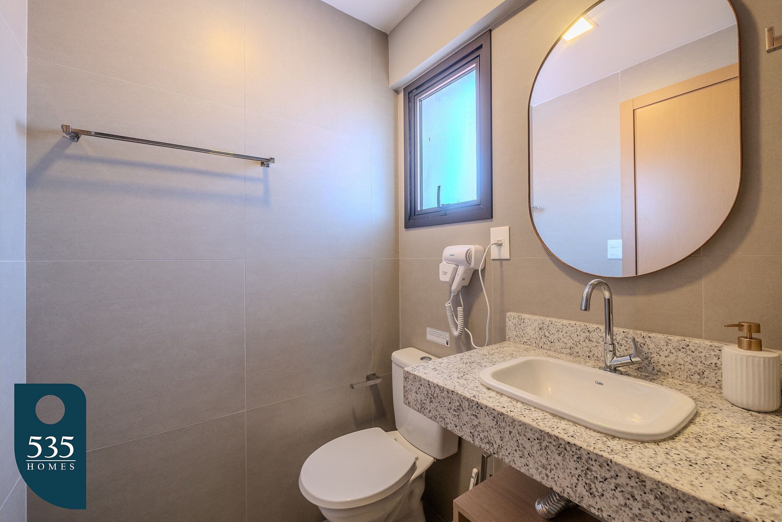 Un baño con inodoro, lavamanos y zona de ducha.