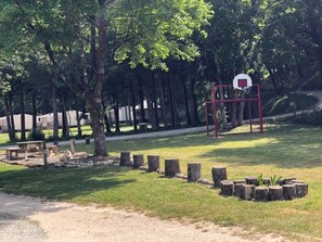 A basketball court with a hoop, surrounded by trees and a picnic area. - Camping 3 étoiles - Piscine  - ccbfa0i (Saint-Mandé-sur-Brédoire)