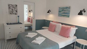 Ett hotellrum med en säng, sängbord, en byrå och en spegel.