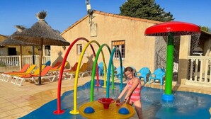A water play area with colorful slides and a pool. - ZEcamping 3 étoiles pataugeoire piscine locatif TV LV clim 33m2 6 pers (Saint-Remy-de-Provence)
