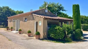 A single-story building with a tiled roof, a small porch, and potted plants. - ZEcamping 3 étoiles pataugeoire piscine locatif TV LV clim 33m2 6 pers (Saint-Remy-de-Provence)