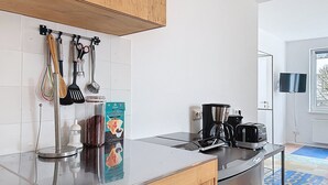Una cocina moderna con electrodomésticos de acero inoxidable, cafetera y hervidor.