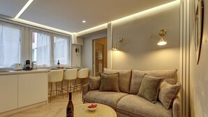 Ein modernes Wohnzimmer mit einer Couch, einem Couchtisch und einer Küchenzeile mit Barhocker.