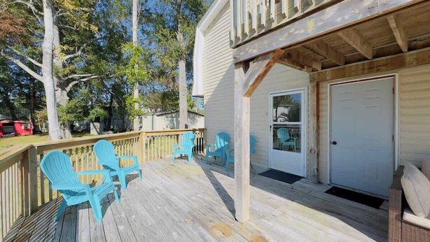 A wooden deck with blue chairs, a covered area, and a door. - Private Villa for Family and group getaway + pool (Murrells Inlet)