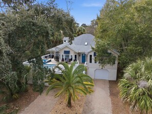 Une maison à deux étages avec un patio couvert, une piscine et un garage.