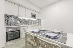 A modern kitchen with white cabinets, a built-in oven, and a tiled backsplash. - Correeira Luxury Residence L (Albufeira)