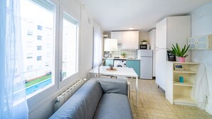 A compact living space with a kitchenette, a dining area, and a sofa. - HomeHolidaysRentals Olimpia - Costa Barcelona (Pineda de Mar)