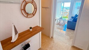 Un baño moderno con tocador de madera, un espejo redondo y una pequeña planta en maceta.