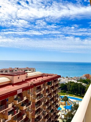 A high-rise hotel with multiple balconies, a swimming pool, and a view of the sea. - BONANZA 1 SUNNY BEDROOM APARTMENT, NEW 2026! (Arroyo de la Miel)