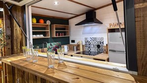 Una cucina moderna con mensole in legno, una cappa aspirante nera e un frigorifero.