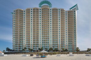 A high-rise hotel with multiple balconies, a beachside location, and a small beach hut. - Aqua Sunset Retreat | Beachfront Condo w/ Large Balcony | Aqua 2003 (Panama City Beach)