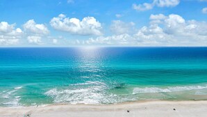 A beach with clear turquoise waters, a sandy shore, and a bright sun. - Aqua Sunset Retreat | Beachfront Condo w/ Large Balcony | Aqua 2003 (Panama City Beach)