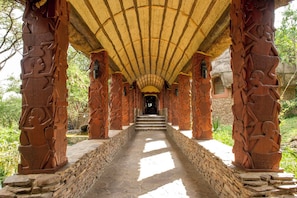 A corridor with stone steps leading to a doorway, flanked by intricately carved columns. - Serengeti Serena Safari Lodge (Serengeti)