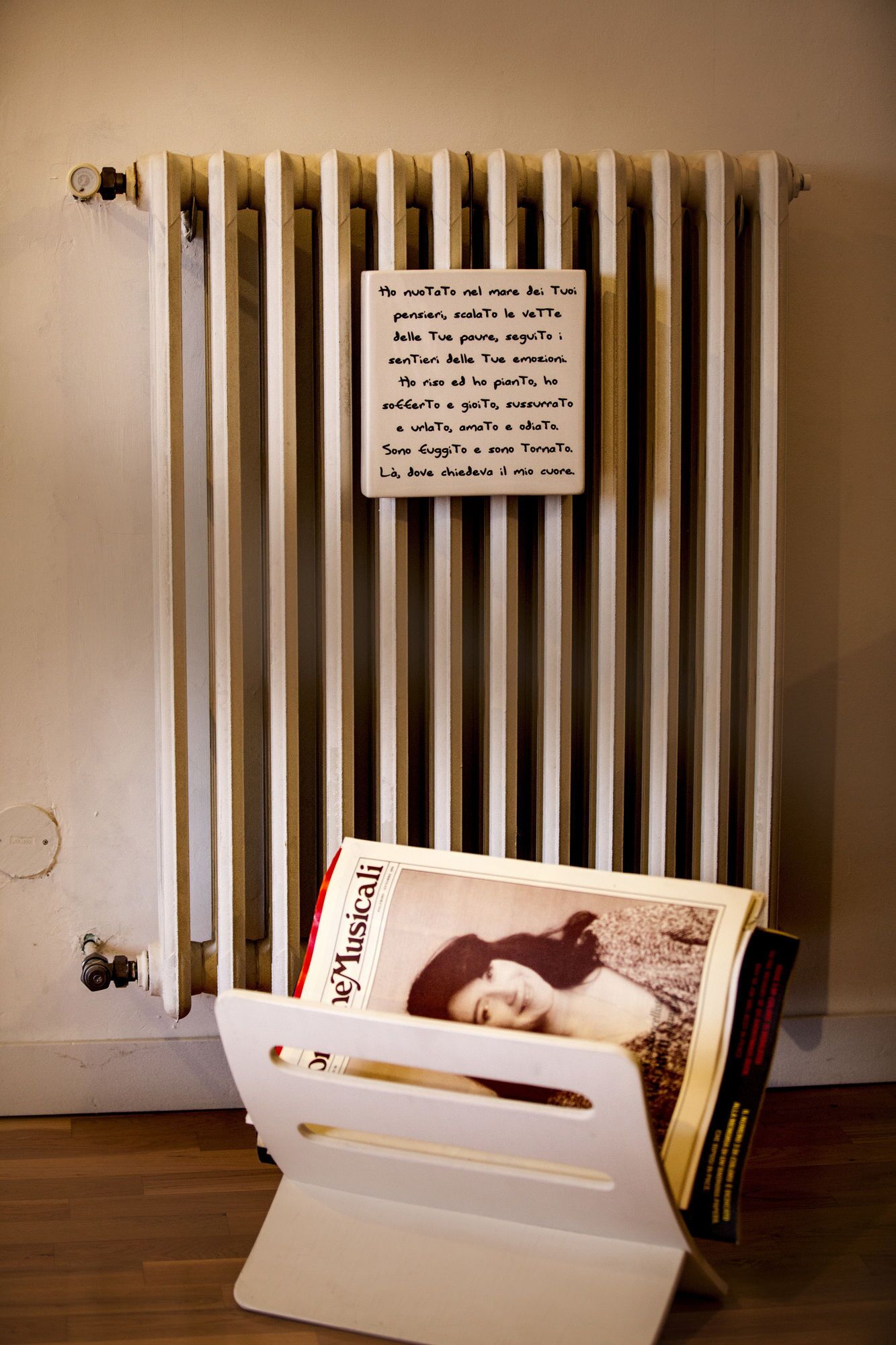 Un radiateur avec un mot écrit à la main et un porte-revues contenant un magazine.
