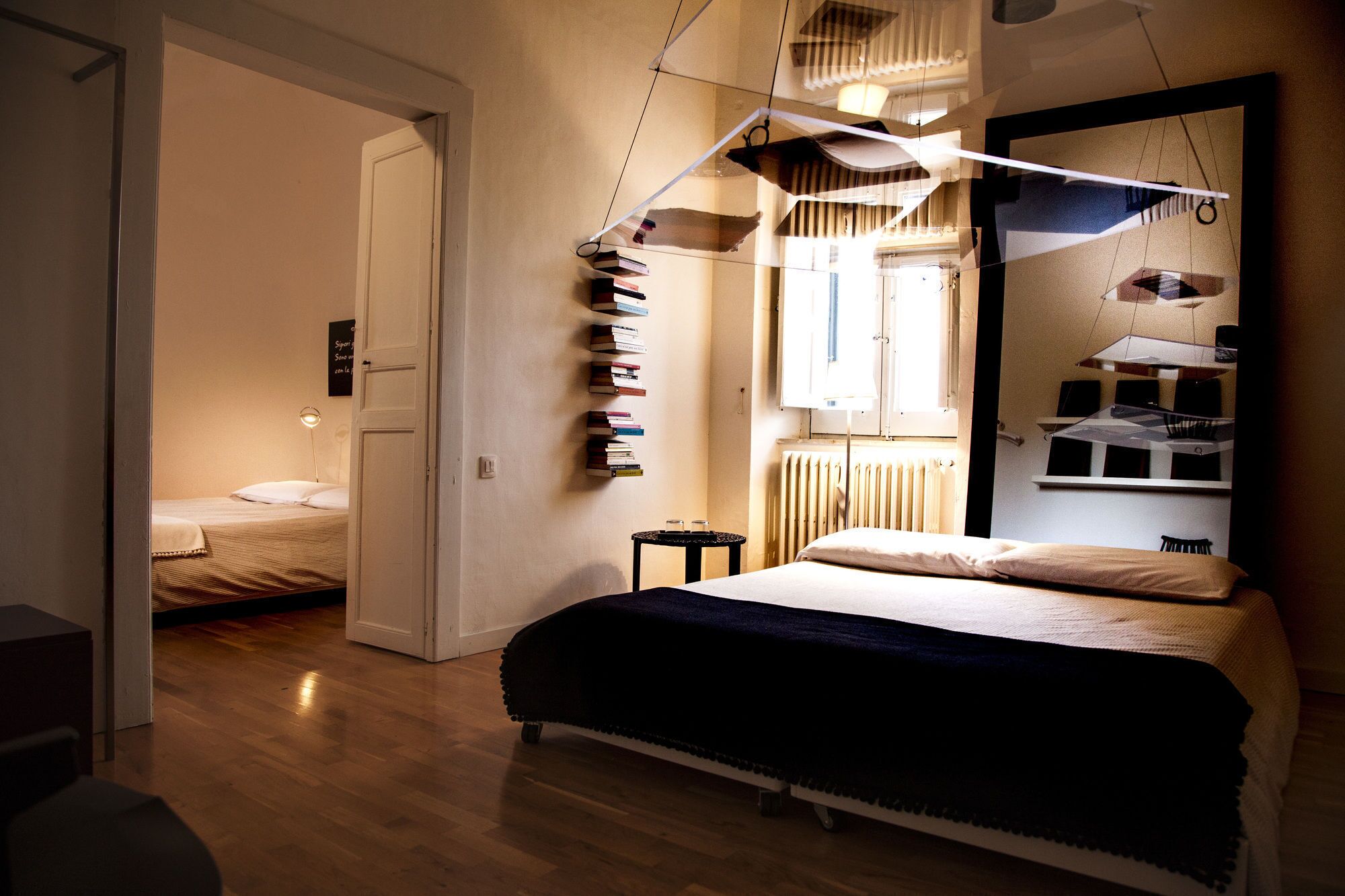 Una camera da letto con un letto, un tavolino, una libreria e un termosifone.