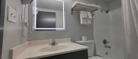 A bathroom with a sink, toilet, and shower.