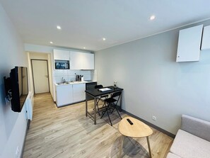 A compact living space with a kitchenette, a dining area, and a small seating area. - La Cour Barbatre | Terrasse (Reims)
