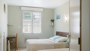 A bedroom with two beds, a desk, and a chair. - Bed and Breakfast 'Chambre D'hôtes Vanille' with Shared Terrace, Private Garden and Wi-Fi (Semussac)