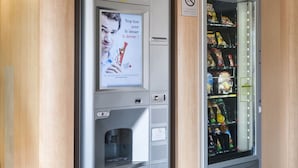 Een automaat bij een B&B hotel, met snacks en een drankdispenser.