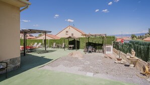 A patio with outdoor furniture, a pergola, and a view of the sea. - Casa Rural El Robledal with Private Pool near Segovia & Madrid, Sleeps 8 (Zarzuela del Monte)