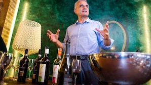 A person standing in a bar with wine bottles and glasses. - Pelagaccio (Peccioli)