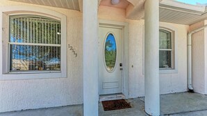 A house with a white exterior, a front door with a glass panel, and a number '213' on the wall. - Resort style living at Warm Mineral Springs , North Port,
Florida (Venice)