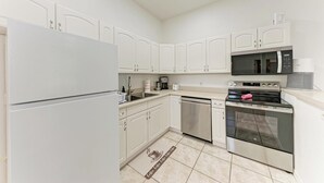 A modern kitchen with white cabinets, a stainless steel refrigerator, a microwave, an oven, and a dishwasher. - Resort style living at Warm Mineral Springs , North Port,
Florida (Venice)