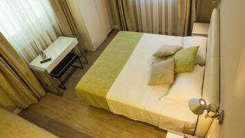Una habitación de hotel con cama, mesita de noche y escritorio con silla.
