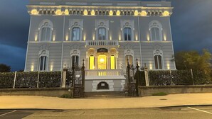 A large, historic building with a symmetrical facade, multiple windows, and a central entrance. - Hotel Universal (Livorno)