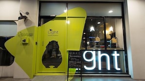 Ein hell erleuchteter Hotelzugang mit einem leuchtenden Neonzeichen mit der Aufschrift "ght".
