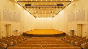 A conference room with a stage, rows of chairs, and a ceiling with lights. - YPJ Hotel (Kaohsiung)