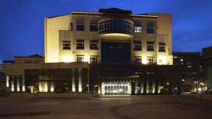 A multi-story hotel with a central atrium and a curved glass facade. - YPJ Hotel (Kaohsiung)
