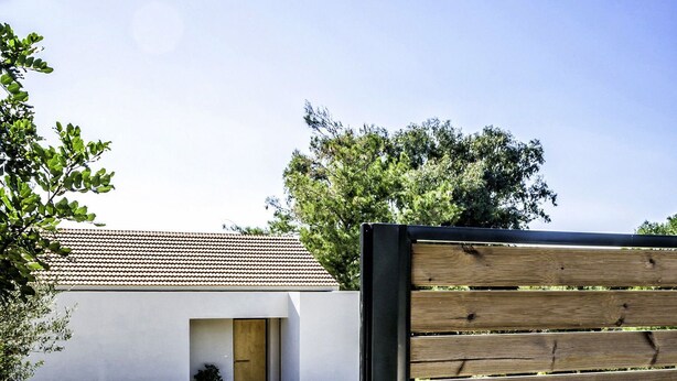 A modern building with a tiled roof and a gravel driveway. - Myrtia Beach House (Chania)