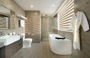 A modern bathroom with a large mirror, a bathtub, a toilet, and a shower area. - Xiamen Air Maple Hotel (Xiamen)